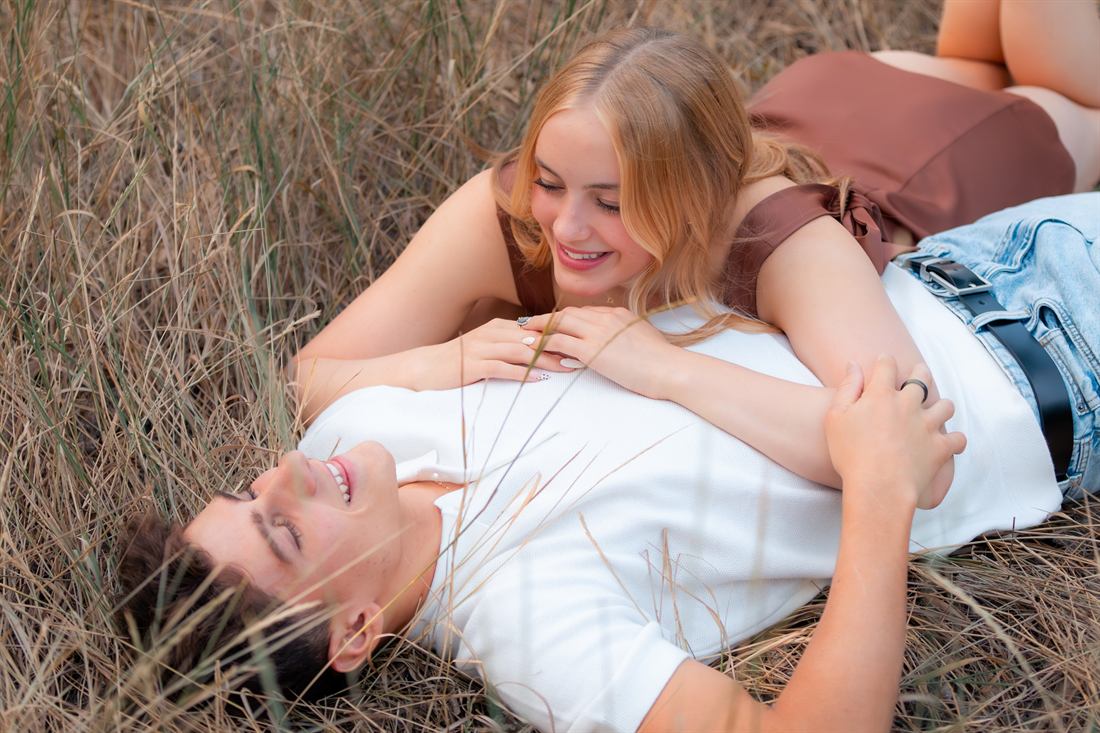 Young couple sharing a candid moment in tall grass
