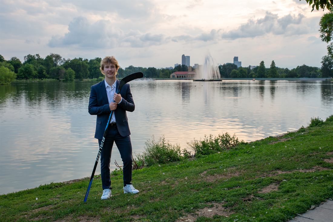 Senior portrait of a hockey player beside a city lake