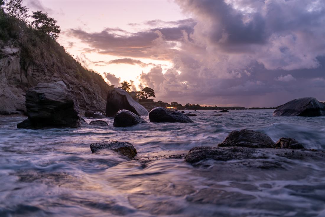 Rocky shoreline beneath a violet sunset
